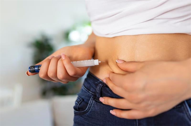 Insulin being injected into abdomen with pen syringe