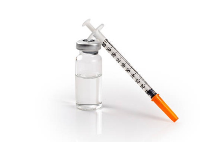 Insulin syringe leaning on vial