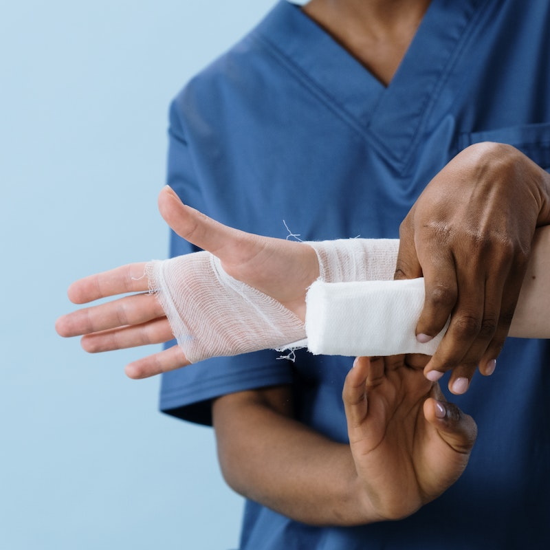 Nurse bandaging patient with gauze