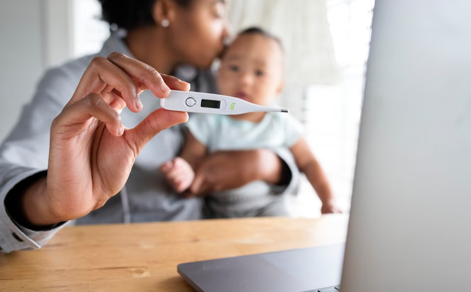 The mother is measuring the temperature of the baby