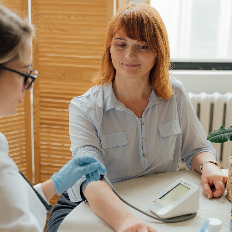 doctor measuring blood pressure of patient